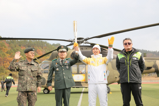 21일 오후 전남 진도군 공설운동장에서 2018 평창동계올림픽 성화를 육군항공작전사령부의 수리온 헬기에 싣기 전 성화주자 서기원 조종사(오른쪽 두번째)가 포즈를 취하고 있다. 헬기에 실린 성화는 신안군 '1004개' 섬을 하늘에서 돈 뒤 목포로 봉송됐다.